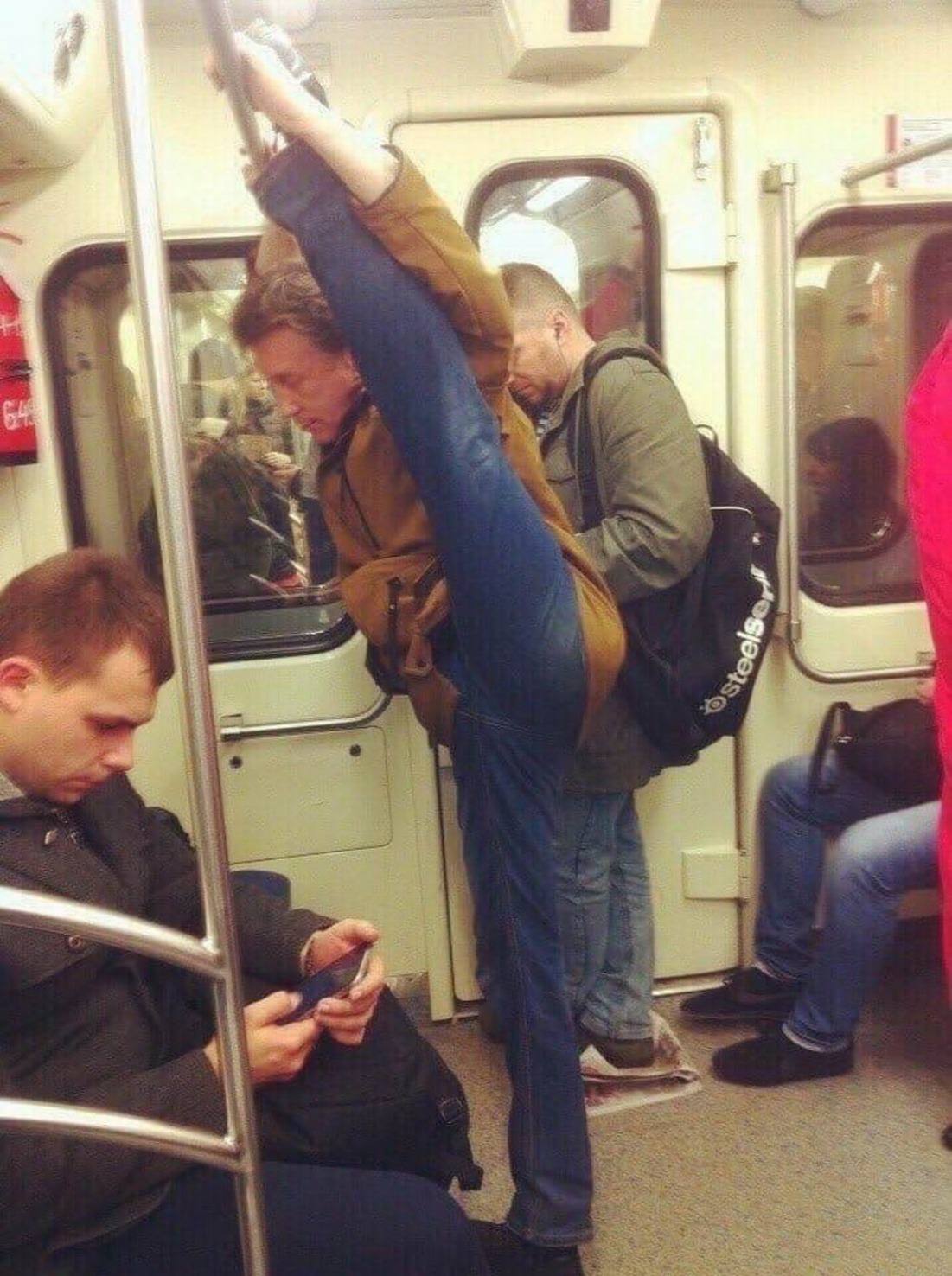 Человек держится за поручень в метро